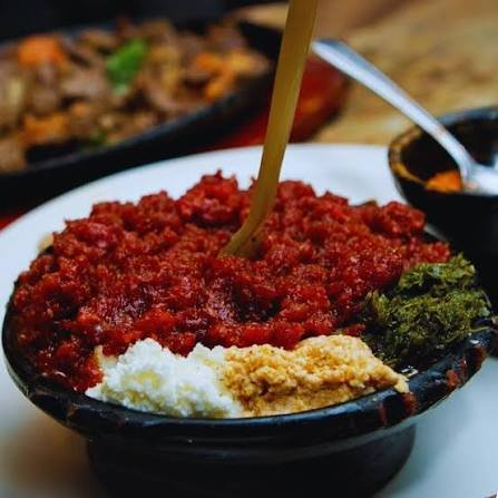 Kitfo with ayib and greens on injera